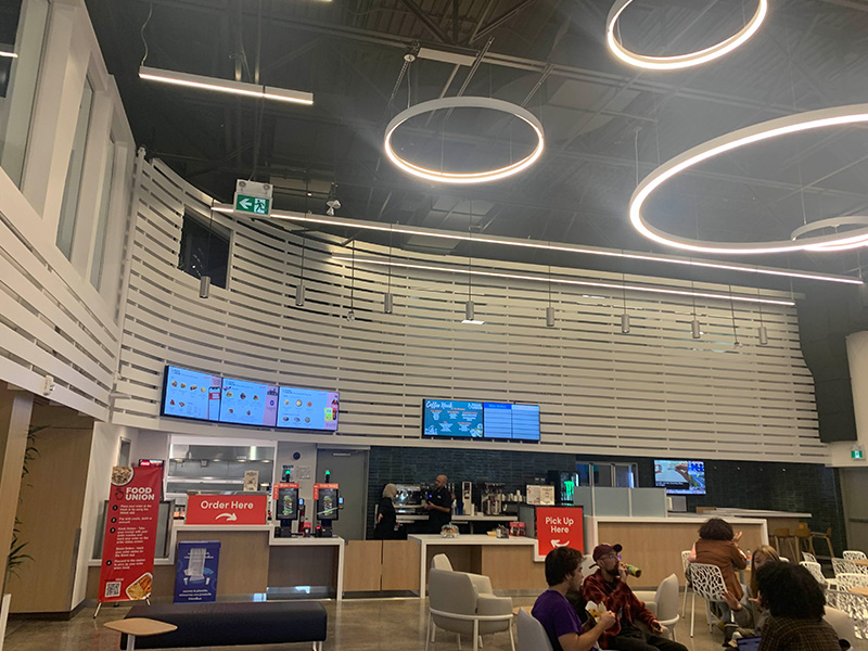 This is the other half of the marquee, where people can order food. Overall it looks fine but there are some details that could be improved. Generally this just supposed to a place to eat and maybe work but some of the layouts for the table are off. The counter area is also a bit off since there's a disconnect between the screens on the wall, and it’s had to gleam what kind of food they sell from a glance.